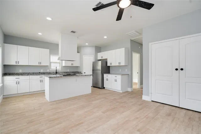 a kitchen with stainless steel appliances kitchen island hardwood floor sink and stove