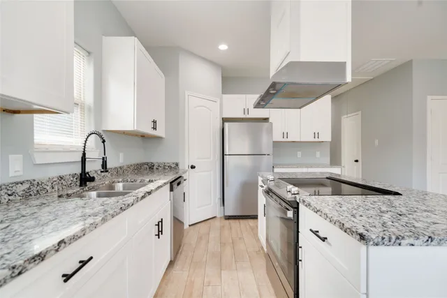 a kitchen with stainless steel appliances granite countertop a sink stove and refrigerator