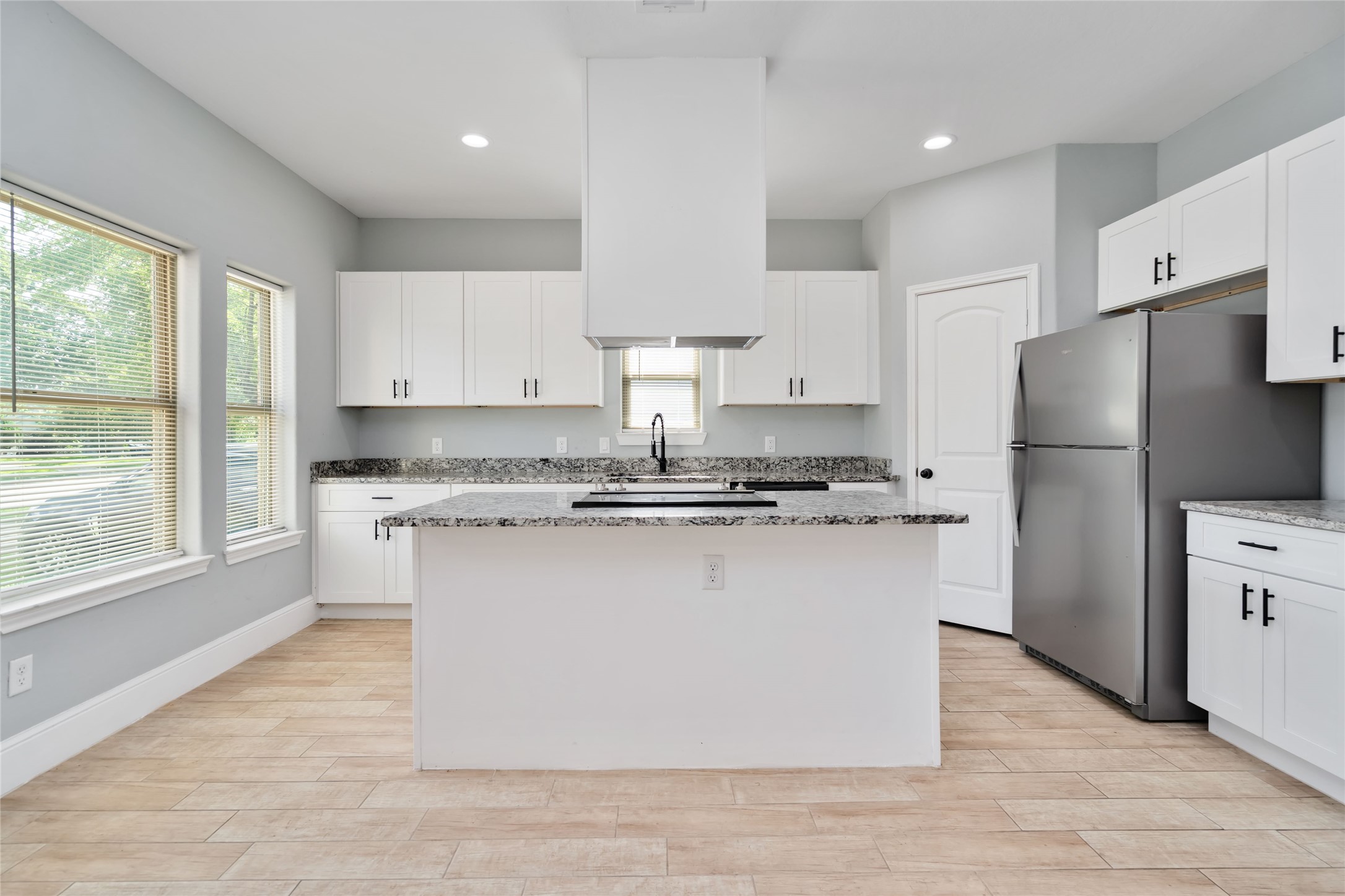 5754 Reed Road, Unit B Houston, TX 77033 - Photo 10 of 29 a kitchen with stainless steel appliances granite countertop a refrigerator a sink dishwasher a stove and white cabinets with wooden floor