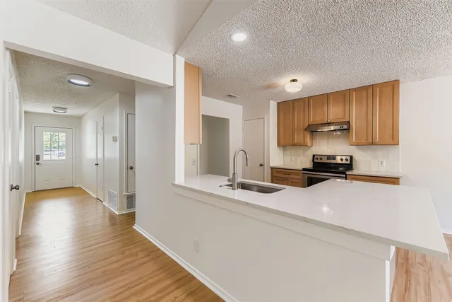 a kitchen with a refrigerator sink and cabinets