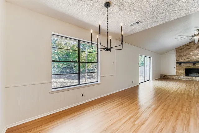 a view of empty room with wooden floor and window