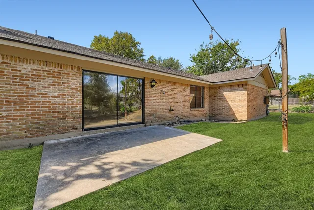 a view of a house with backyard and a tree