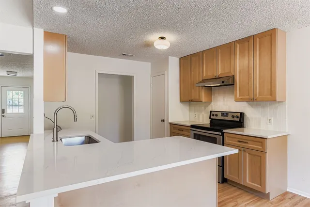 a kitchen with stainless steel appliances a sink stove and cabinets