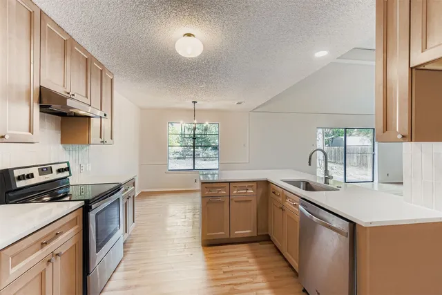 a kitchen with a sink stove and cabinets