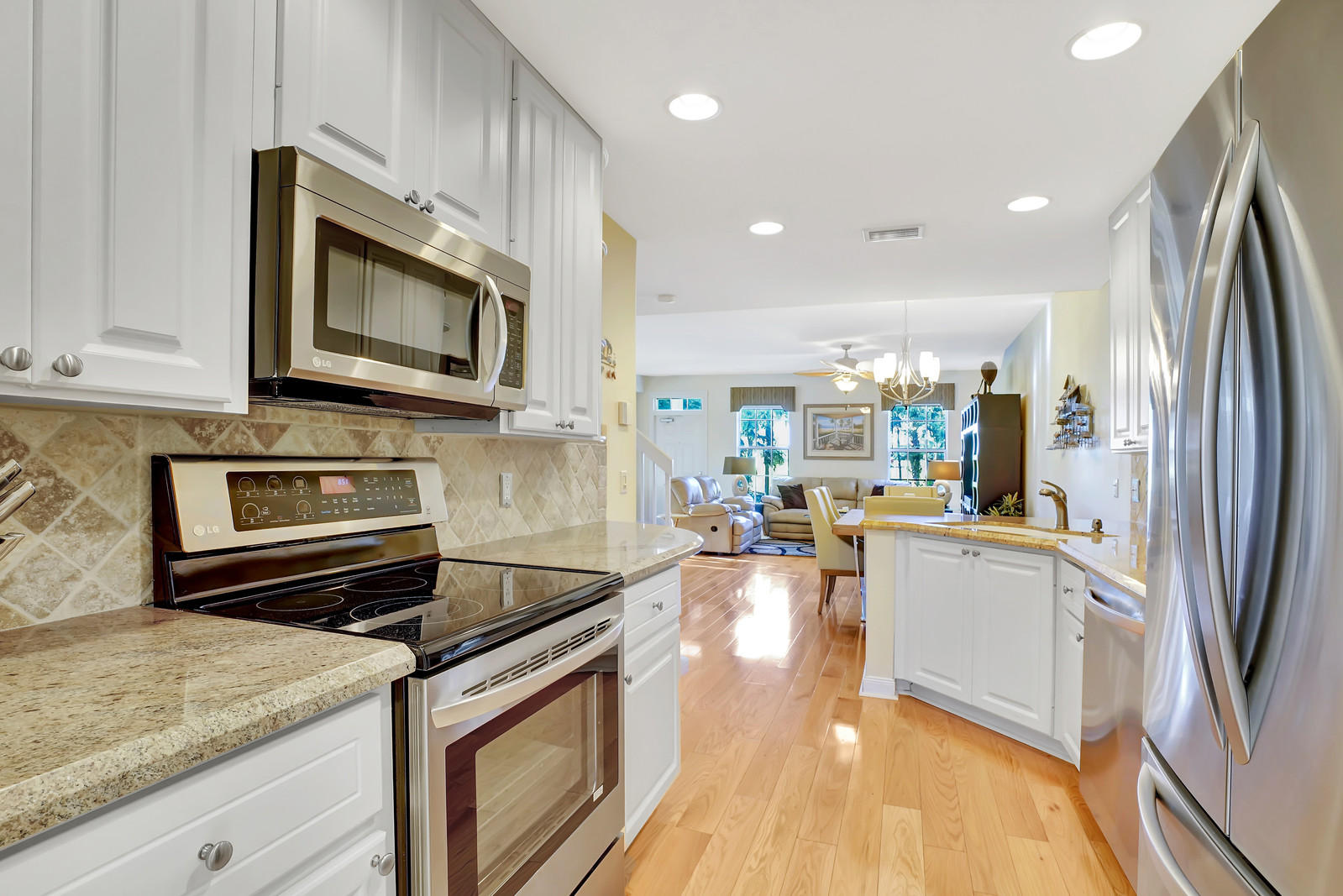 144 Radcliffe Court Jupiter, FL 33458 - Photo 28 of 28 a kitchen with stainless steel appliances granite countertop a refrigerator stove microwave and sink