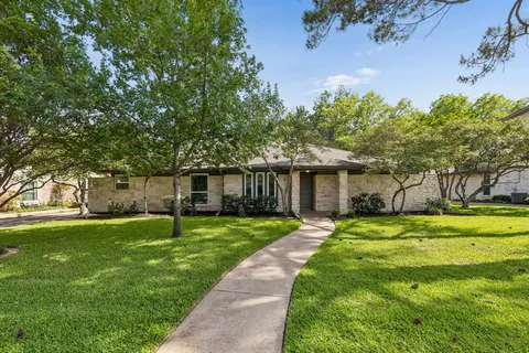 a front view of a house with a yard and trees