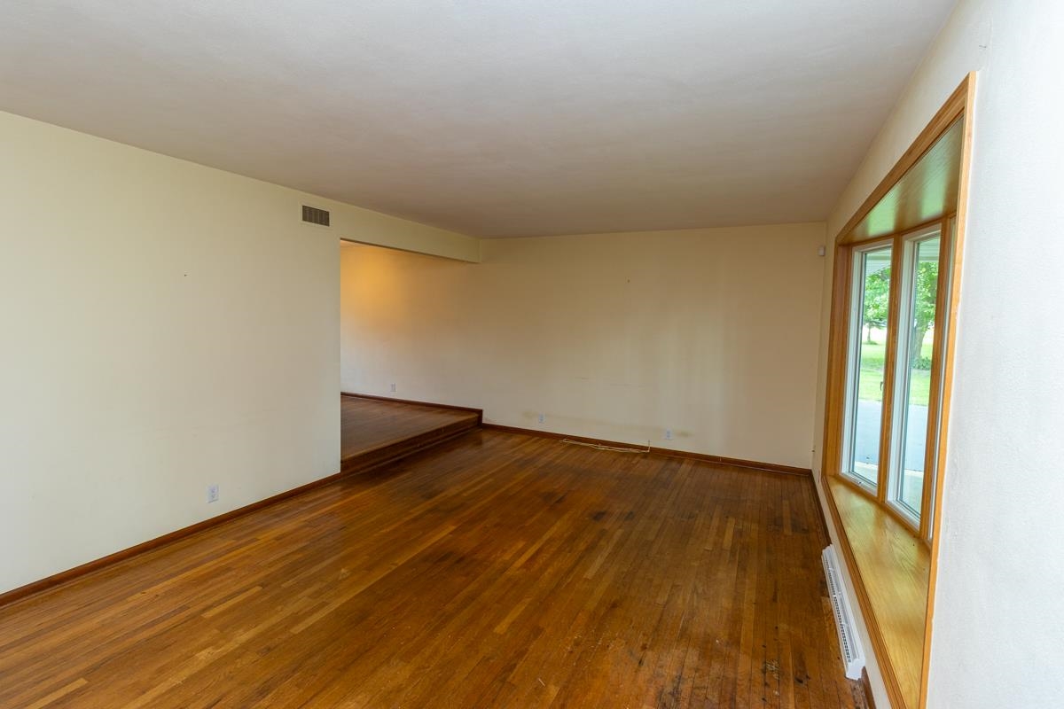 3096 East Water Road Byron, IL 61010 - Photo 5 of 29 a view of an empty room with wooden floor and a window