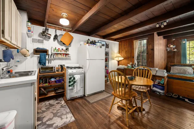 a utility room with stainless steel appliances wooden floors and furniture