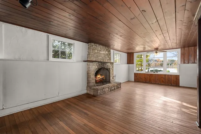 a view of a livingroom with furniture a fireplace and wooden floor