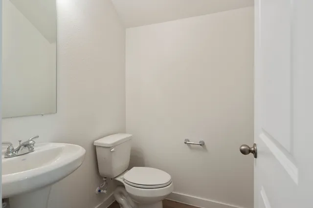 a white toilet sitting next to a bathroom sink