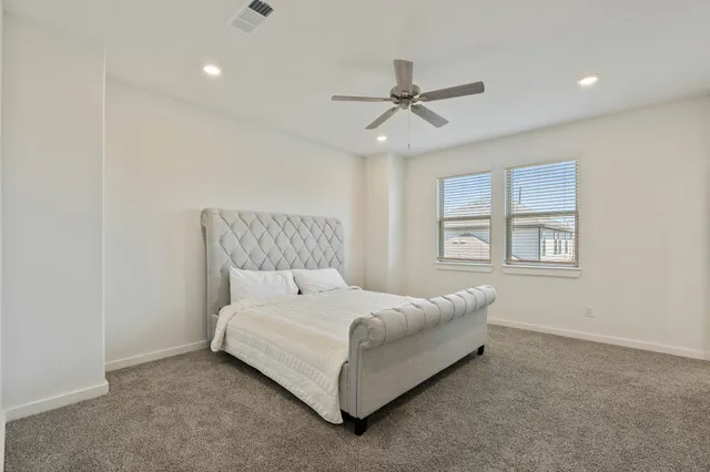 a large bedroom with a bed and a window