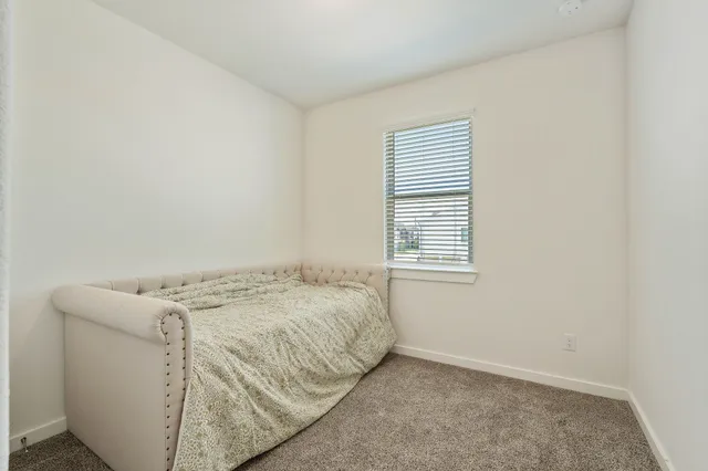 a bed sitting in a bedroom next to a window