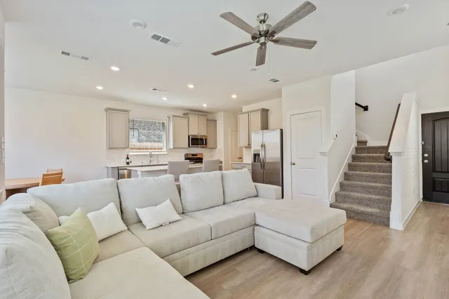 a living room with furniture and a view of kitchen