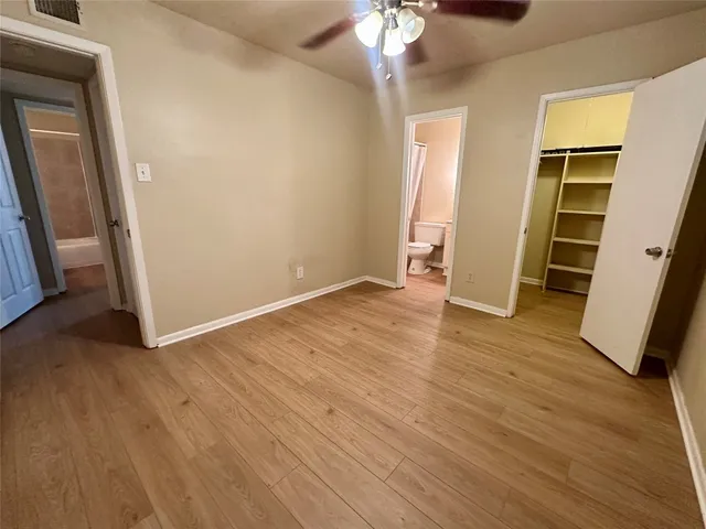 an empty room with wooden floor and closet