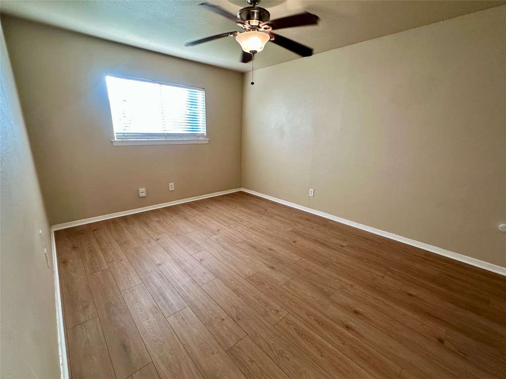 803 West 28th Street, Unit 106 Austin, TX 78705 - Photo 5 of 20 an empty room with wooden floor fan and windows