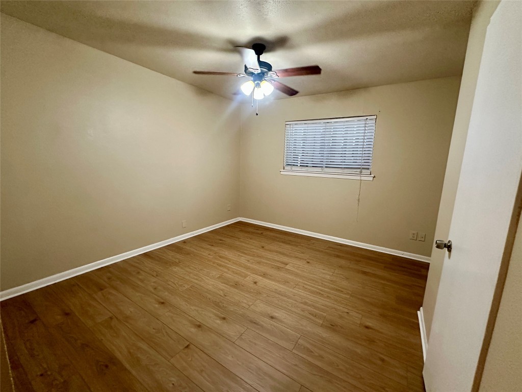 803 West 28th Street, Unit 106 Austin, TX 78705 - Photo 7 of 20 a view of a room with wooden floor and a ceiling fan