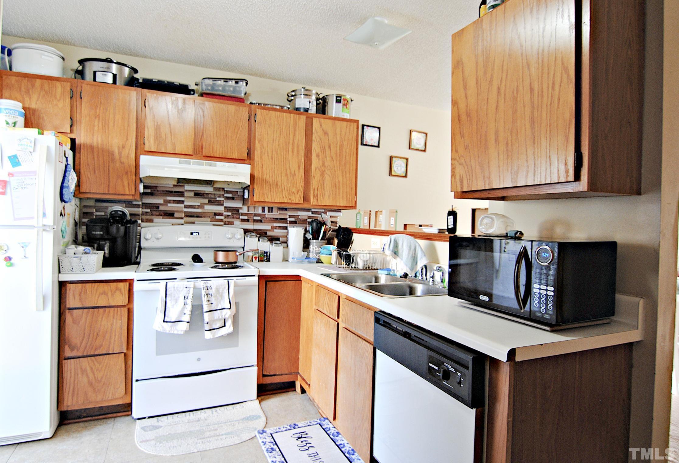 8263 Merriweather Circle Raleigh, NC 27616 - Photo 6 of 10 a kitchen with a sink stove and cabinets