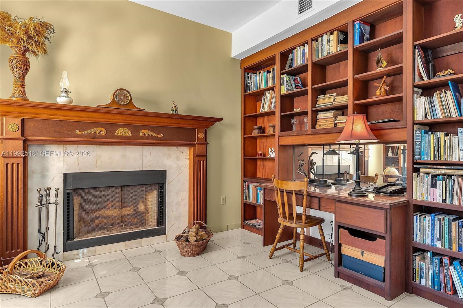 5309 Alton Road Miami Beach, FL 33140 - Photo 9 of 51 a living room with a bookshelf and a fireplace