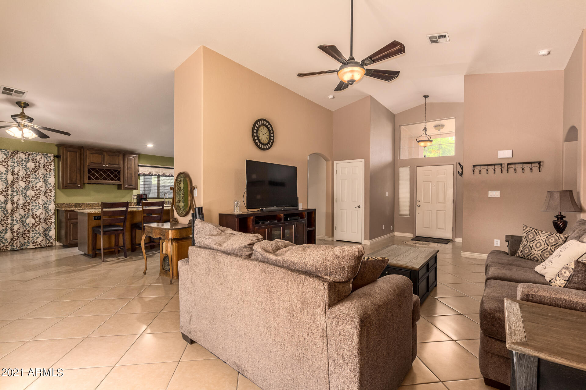 253 East Nunneley Road Gilbert, AZ 85296 - Photo 8 of 25 a living room with furniture a clock and a ceiling fan