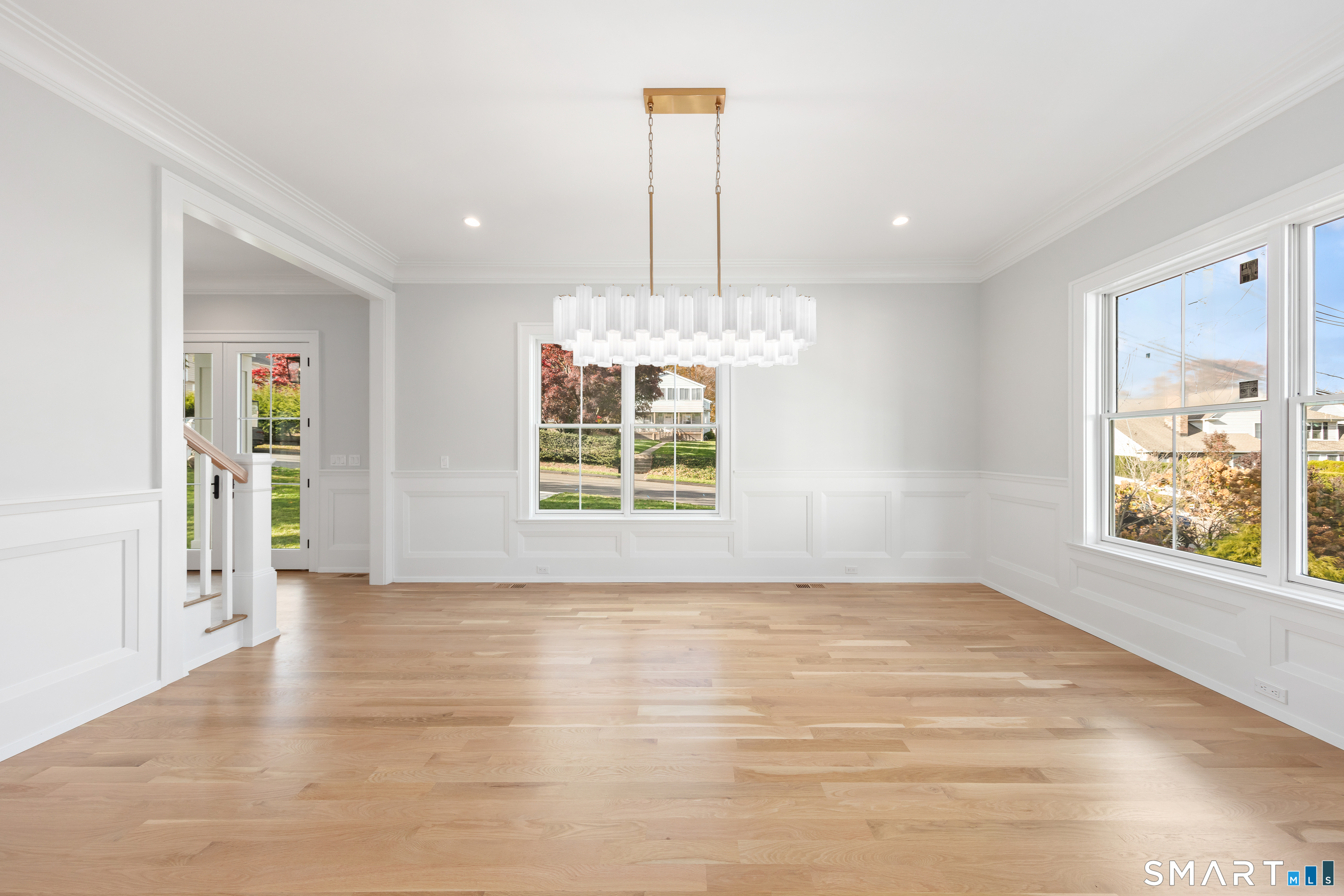 119 Harrison Avenue New Canaan, CT 06840 - Photo 5 of 40 an empty room with chandelier fan and windows