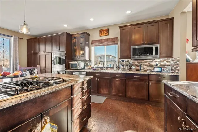 a kitchen with stainless steel appliances granite countertop a refrigerator and a sink