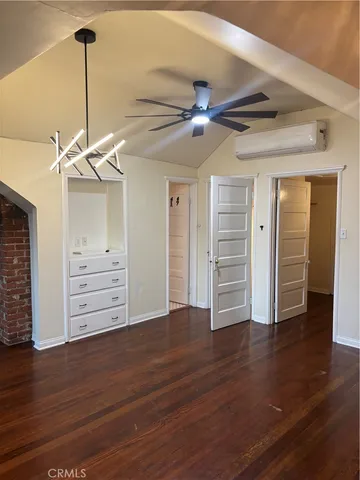 a view of a room with wooden floor ceiling fan and window