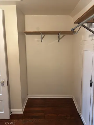 a view of a room with wooden floor and small window