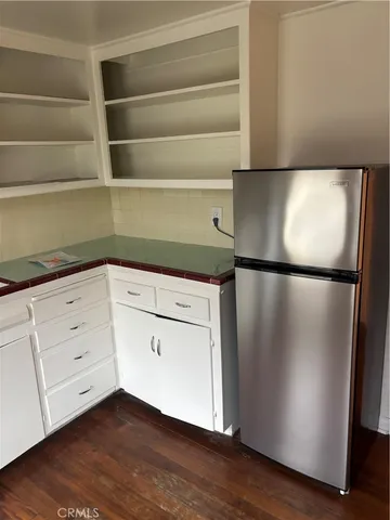 a kitchen with a white cabinets and a wooden floor