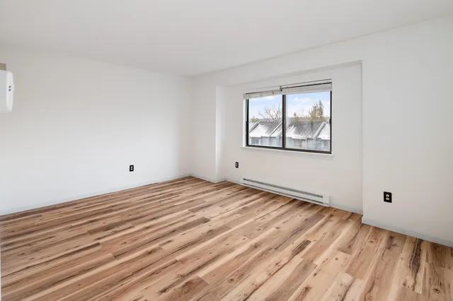 a view of a room with wooden floor and bathroom