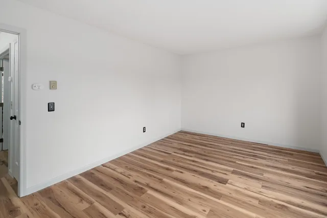 a view of a room with wooden floor and window