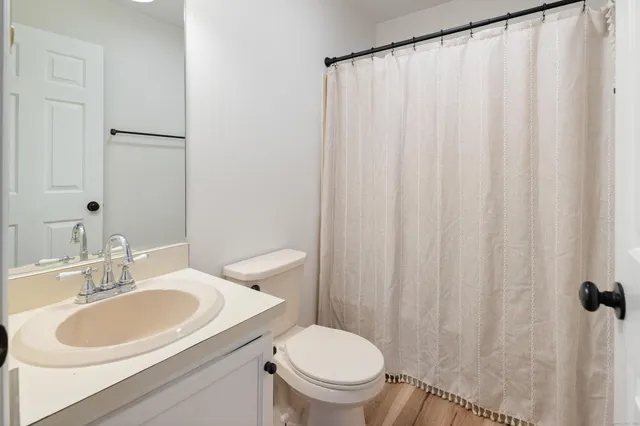 a bathroom with a sink a toilet and a mirror