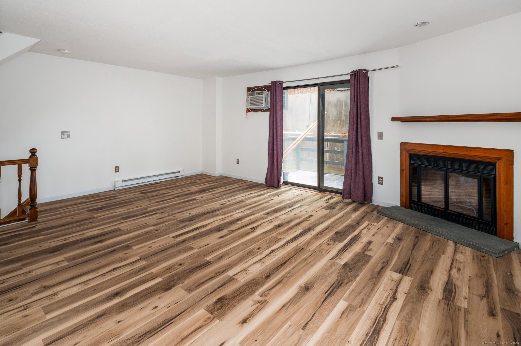 8 Driftway Road, Unit C1 Danbury, CT 06811 - Photo 3 of 23 a view of an empty room with wooden floor fireplace and a window