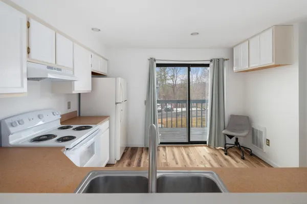 a kitchen with a sink a refrigerator and white cabinets