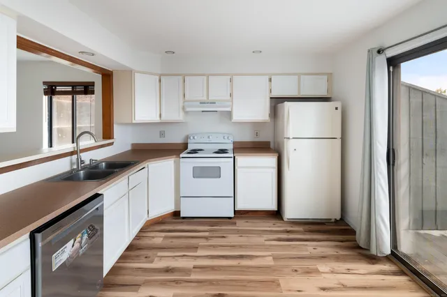 a kitchen with granite countertop a sink a stove and cabinets