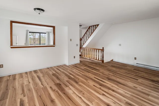 a view of a hallway with wooden floor and staircase