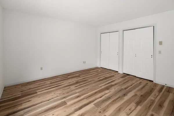 a view of a room with wooden floor and white doors