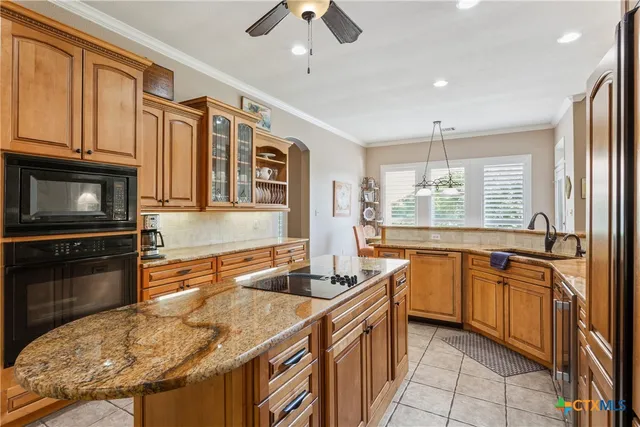 a kitchen with stainless steel appliances granite countertop a sink and a stove
