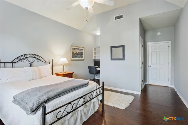 a bedroom with a bed and wooden floor