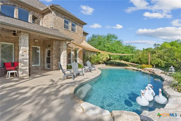 a view of a house with a backyard porch and sitting area