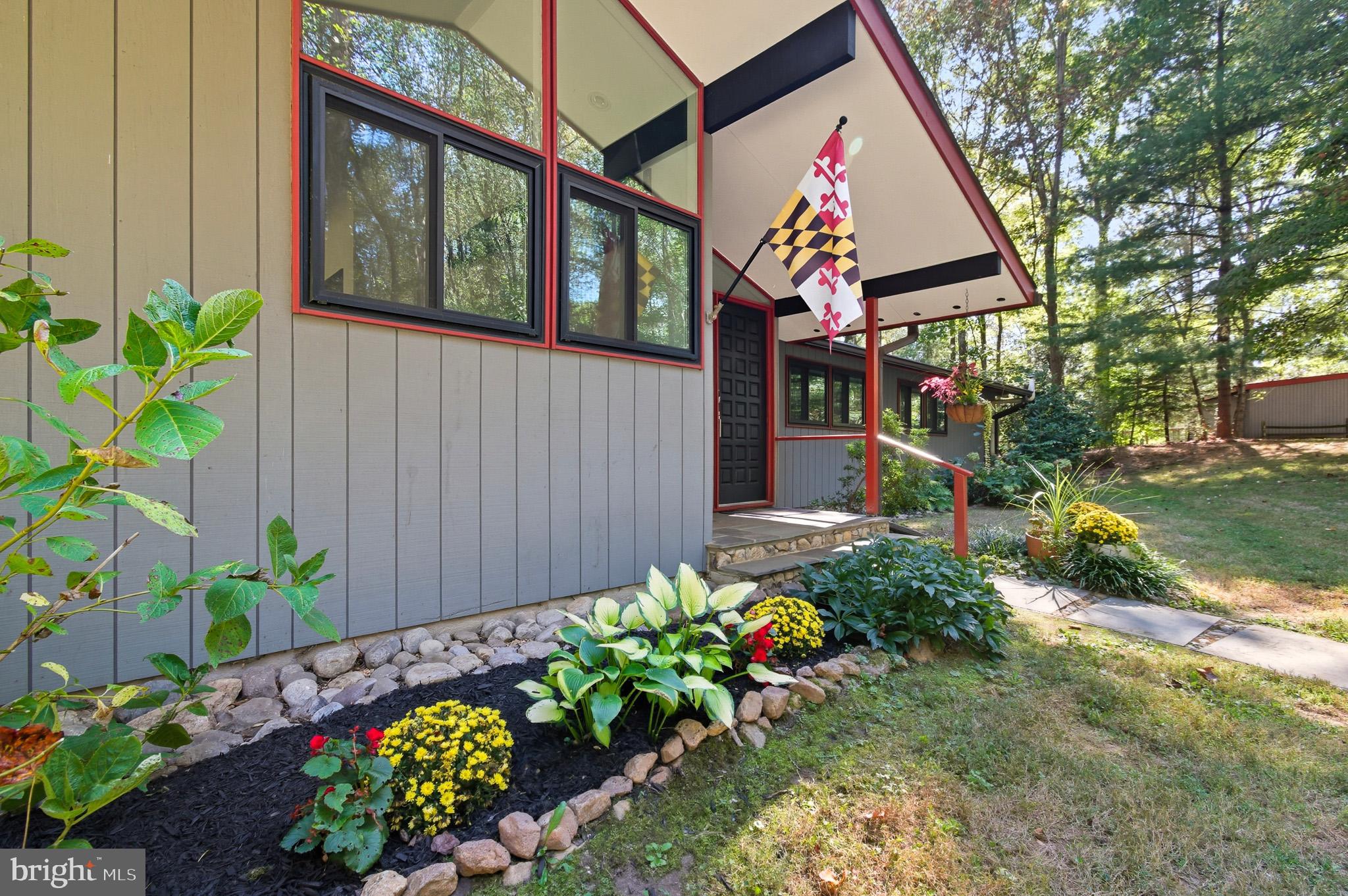 7145 Deer Valley Road Highland, MD 20777 - Photo 1 of 75 a front view of a house with a yard and flowers