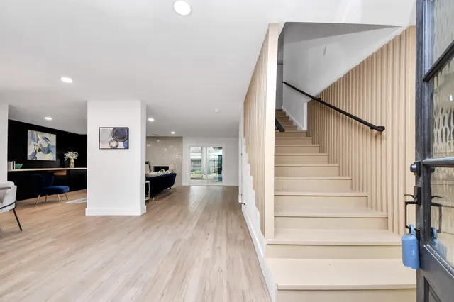 a view of a living room with wooden floor and stairs