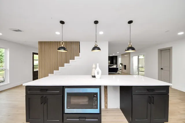 a kitchen with stainless steel appliances kitchen island granite countertop a sink and cabinets