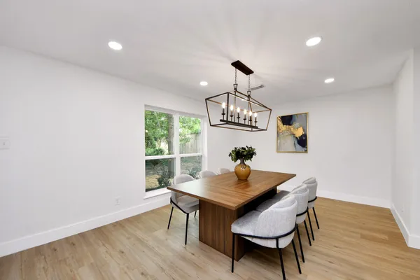 a view of a dining room with furniture a chandelier and wooden floor