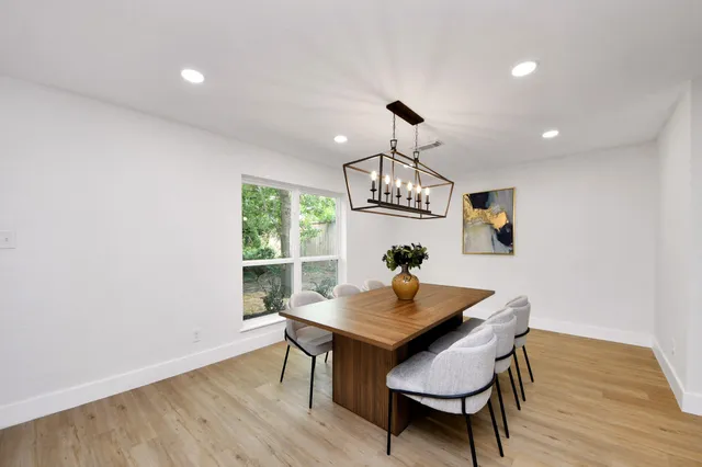 a view of a dining room with furniture a chandelier and wooden floor
