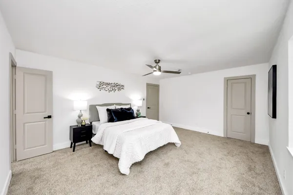 a spacious bathroom with a toilet a sink and a mirror