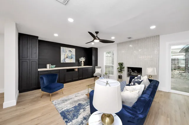a living room with fireplace furniture and a wooden floor