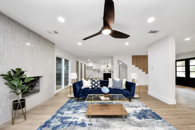 a living room with furniture hard wood floor and a chandelier