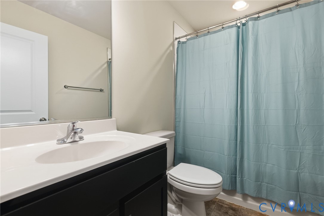 1925 Kennington Park Road Aylett, VA 23009 - Photo 22 of 32 a bathroom with a sink a toilet a mirror and shower curtain
