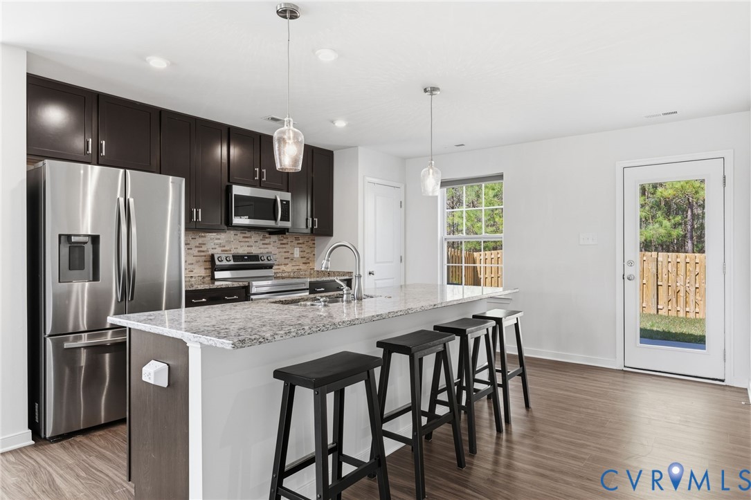 1925 Kennington Park Road Aylett, VA 23009 - Photo 10 of 32 a kitchen with stainless steel appliances granite countertop a refrigerator a stove a sink dishwasher a dining table and chairs with wooden floor