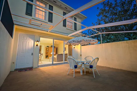 a patio with a yard and a table and chairs